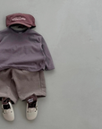 Braunes Boxy-Longsleeve mit passender Hose und Cap – entspannter Look.