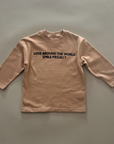 Beiges Longsleeve mit schwarzem Schriftzug „LOVE AROUND THE WORLD SMILE PROJECT“ auf der Vorderseite.