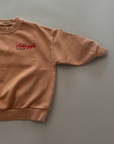 Beiges Sweatshirt mit kleinem roten „Kellogg’s“ Print auf der Brust, Rundhalsausschnitt und gerippten Bündchen.