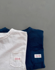 Dunkelblaues und cremefarbenes Longsleeve-Tee übereinandergelegt – minimalistisches Design.