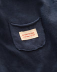 Nahaufnahme des kleinen Labels auf der Brust des dunkelblauen Longsleeve-Tees.