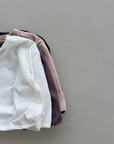 Vier Longsleeves mit Boxy-Schnitt in verschiedenen Farben übereinandergelegt