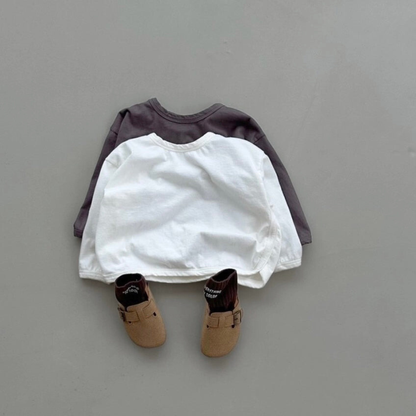 Zwei Boxy-Longsleeve in ivory und braun, kombiniert mit dunklen Schuhen.