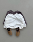 Zwei Boxy-Longsleeve in ivory und braun, kombiniert mit dunklen Schuhen.