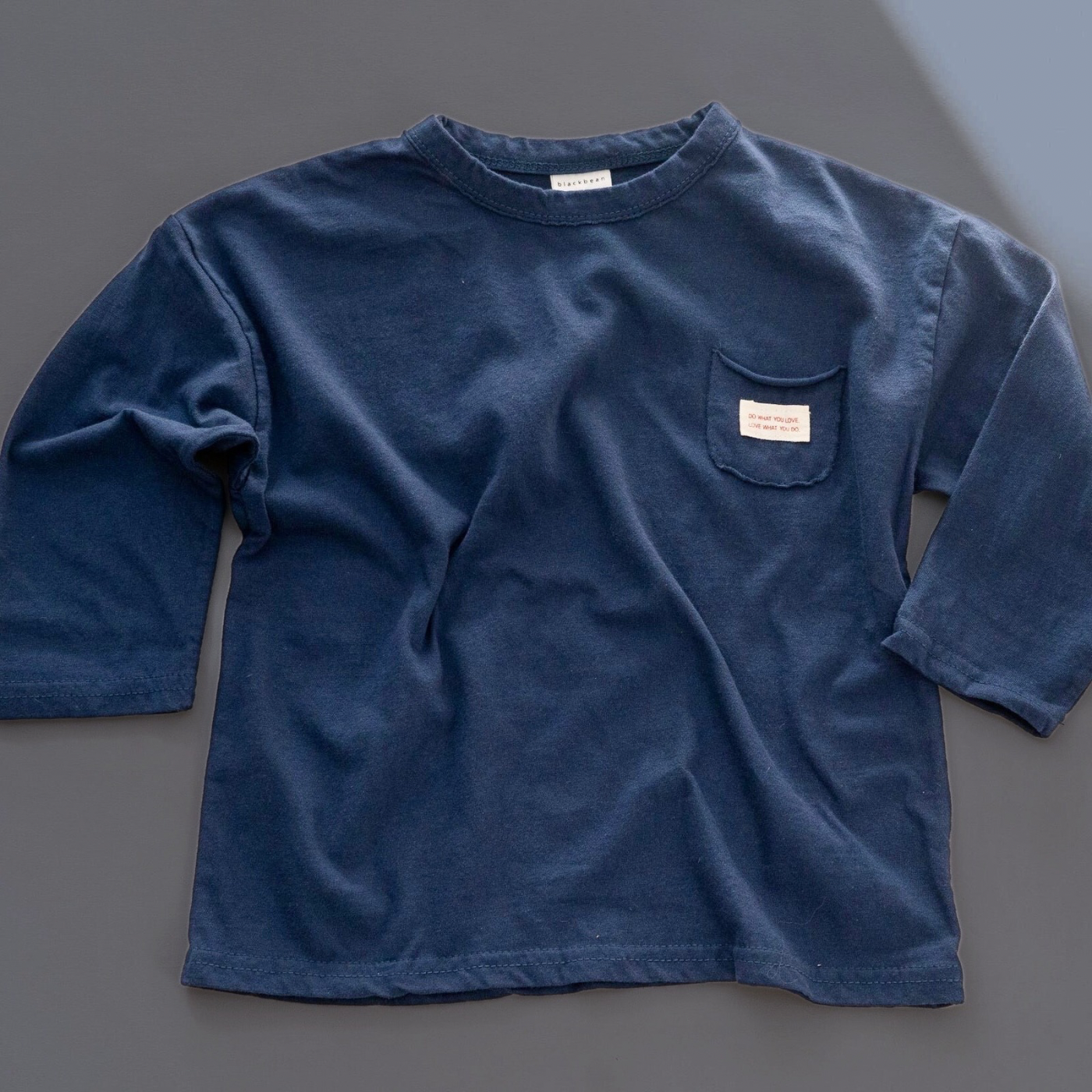 Dunkelblaues Longsleeve mit kleiner Tasche auf der Brust und Label Patch Detail