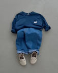 Dunkelblaues Longsleeve mit Jeans und passenden Schuhen