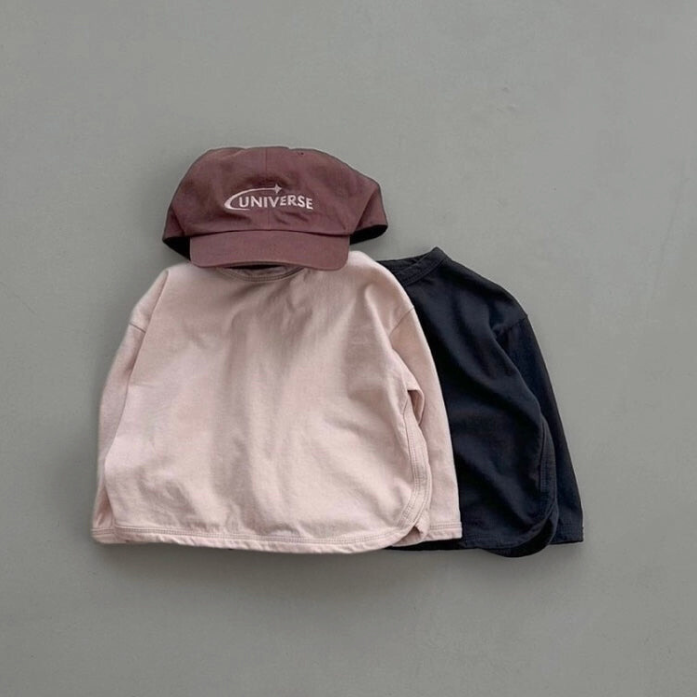 Roséfarbenes und schwarzes Longsleeve mit Boxy-Schnitt kombiniert mit Cap