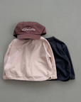 Roséfarbenes und schwarzes Longsleeve mit Boxy-Schnitt kombiniert mit Cap