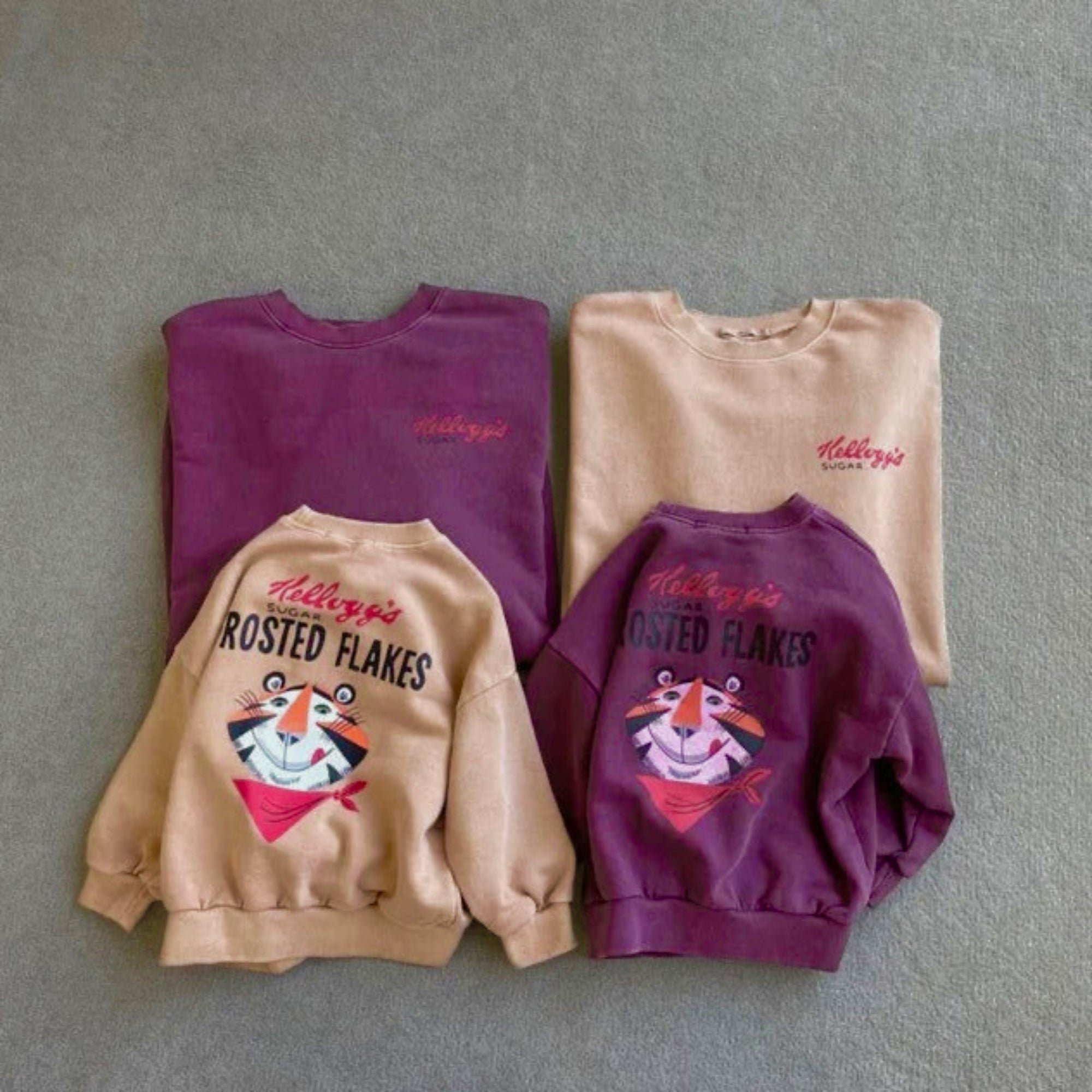 Kinder und Erwachsenen „Frosted Flakes“ Sweatshirts in Beige und Lila – mit kleinem „Kellogg’s“ Print vorne und großem Print hinten.