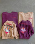 Kinder und Erwachsenen „Frosted Flakes“ Sweatshirts in Beige und Lila – mit kleinem „Kellogg’s“ Print vorne und großem Print hinten.