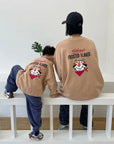 Kind und Erwachsener im beigen „Frosted Flakes“ Sweatshirt – großer Print mit Tony der Tiger auf dem Rücken.