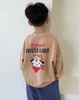 Kind trägt das beige „Frosted Flakes“ Sweatshirt – großer Tony der Tiger Print auf dem Rücken sichtbar.