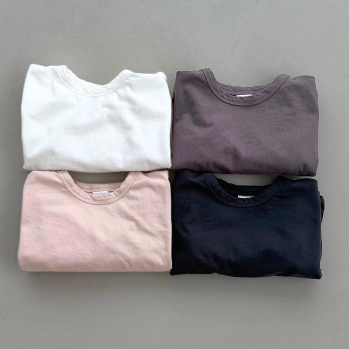 Vier Boxy-Longsleeves in Ivory, Rosé, braun und schwarz, zusammengelegt