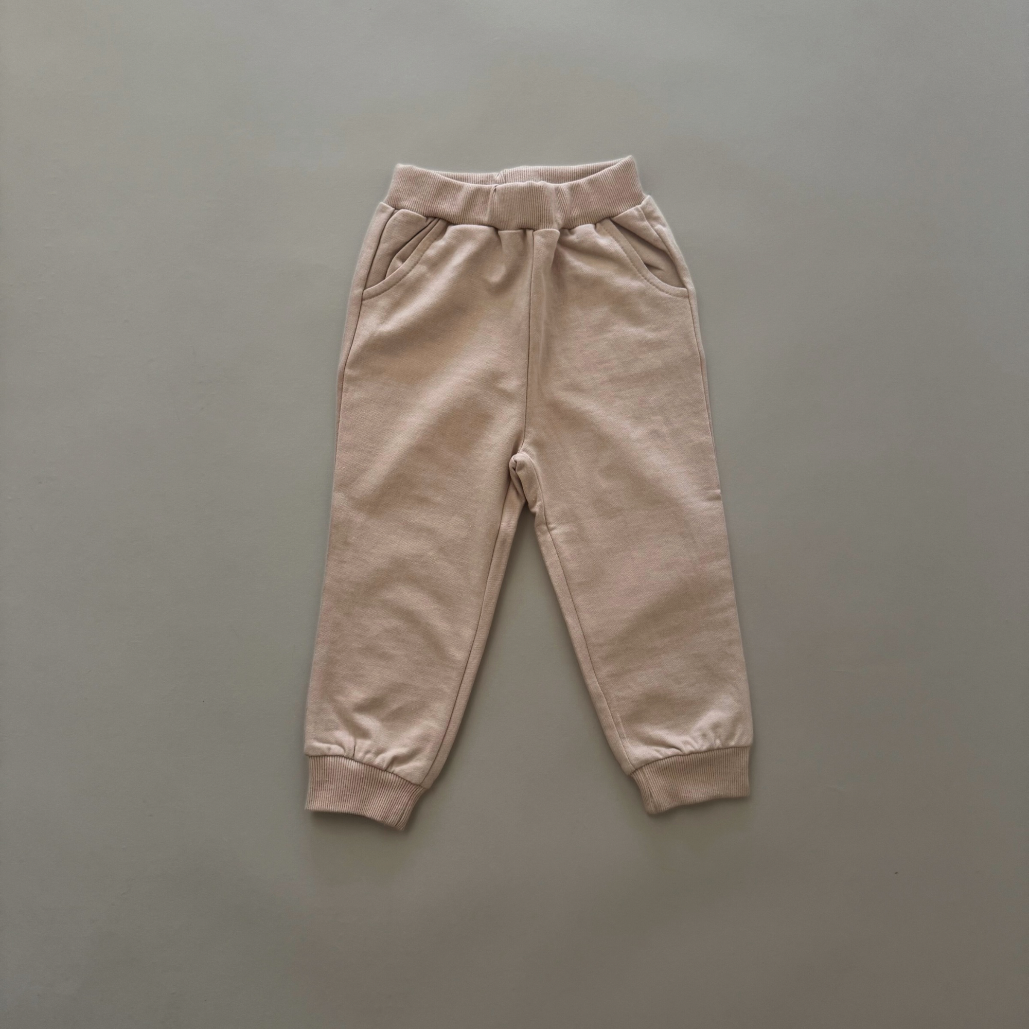 Beige Jogginghose – Bequeme Hose mit elastischem Bund und Bündchen am Beinabschluss.