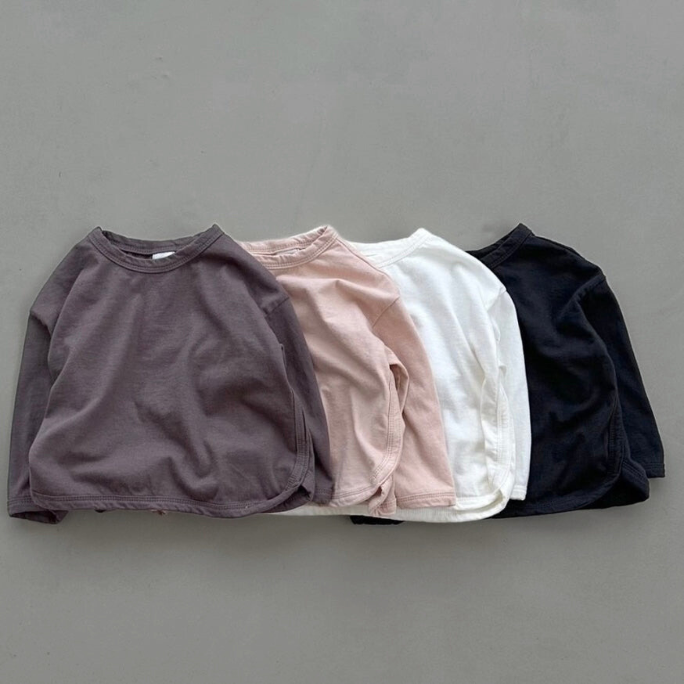 Vier Longsleeves mit Boxy-Schnitt in verschiedenen Farben – Ivory, Rosé, braun und schwarz.