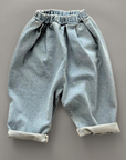 Hellblaue Kinderjeans mit hochgekrempelten Hosenbeinen für einen lässigen Look.