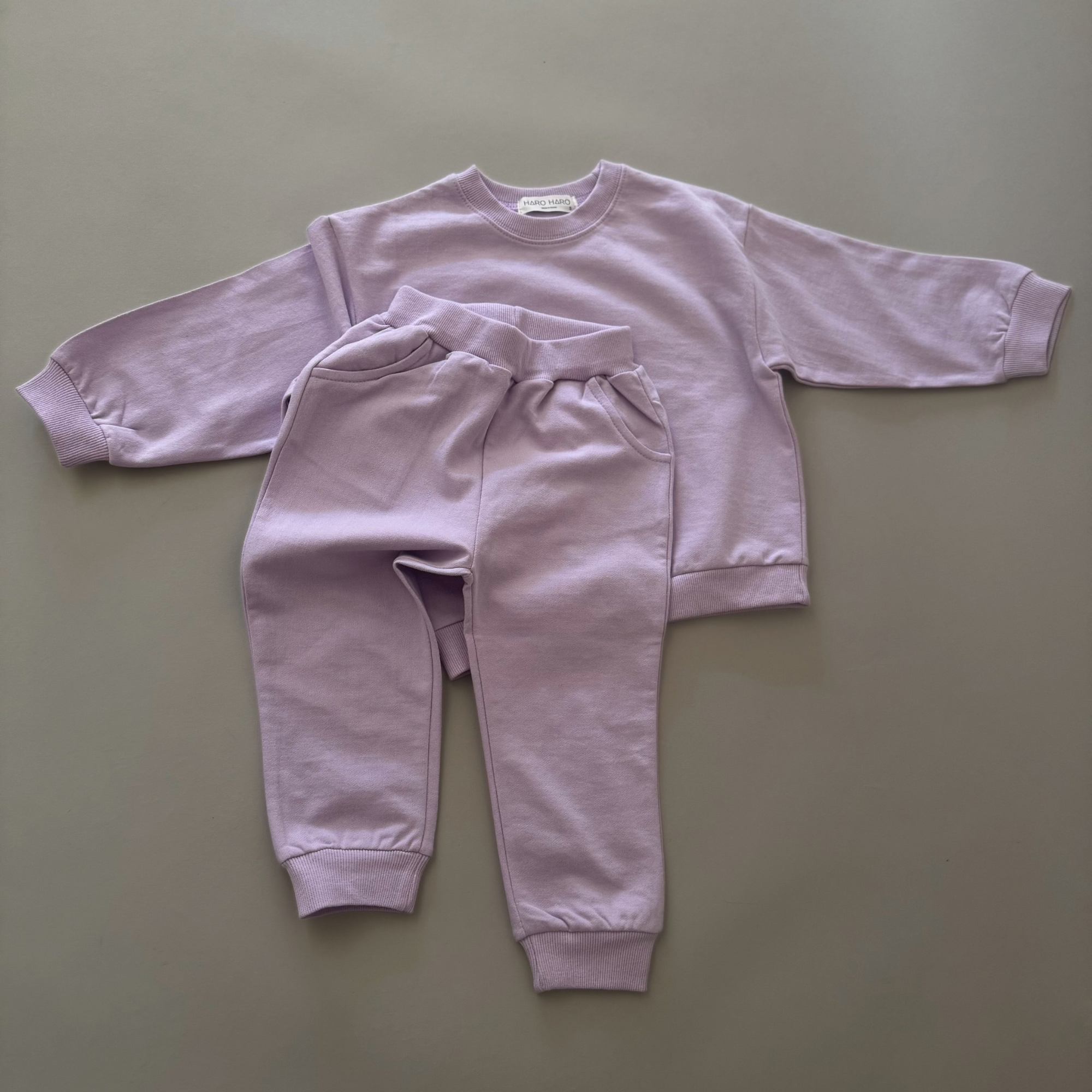 Lilac Sweat Set – Pullover und Jogginghose locker drapiert für einen entspannten Look.