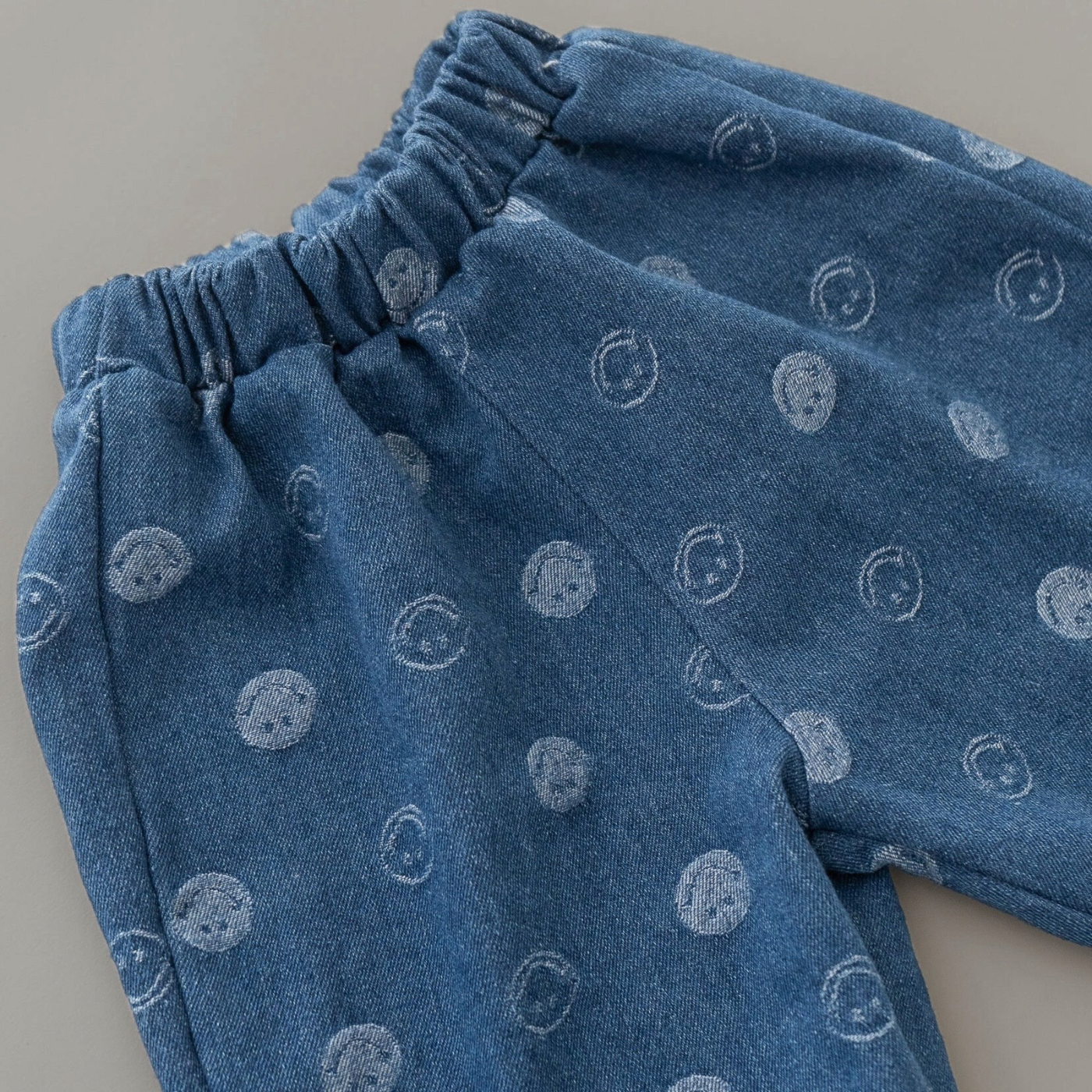 Nahaufnahme der blauen Denim-Hose mit elastischem Bund und Smileys.